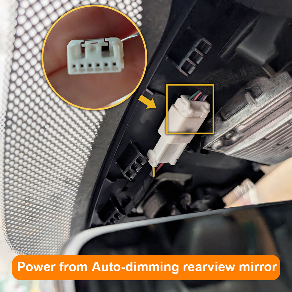 Close-up of a car's auto-dimming rearview mirror with wiring and connectors.