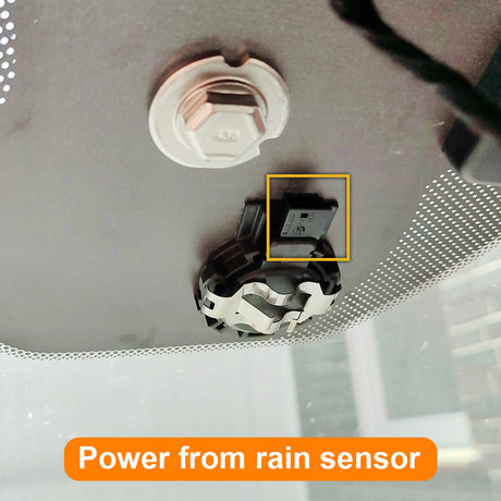 Close-up of a rain sensor on a car's interior ceiling with text indicating power from rain sensor.