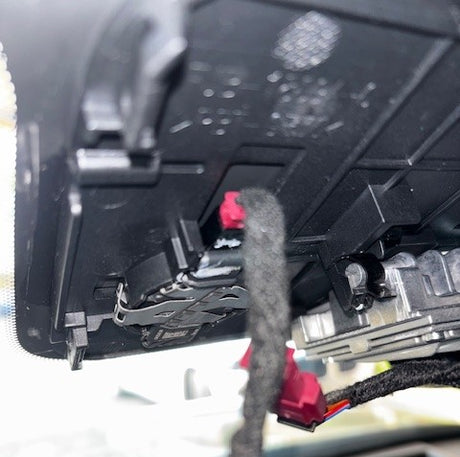 Close-up of a car's undercarriage rain sensor connector plug.