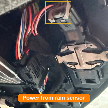 Close-up of car interior with wiring and rain sensor power indicator.